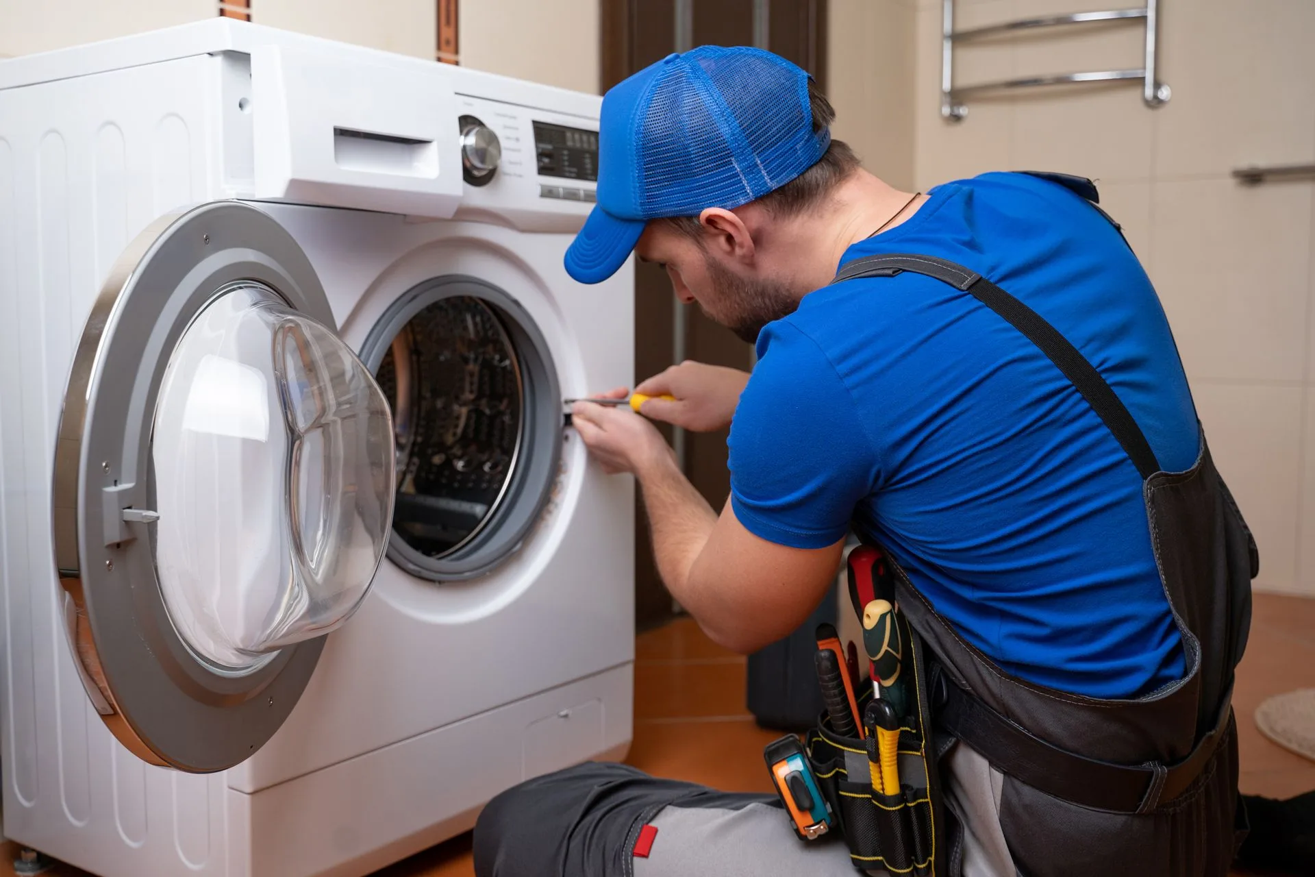 Appliance technician inspecting a washing machine